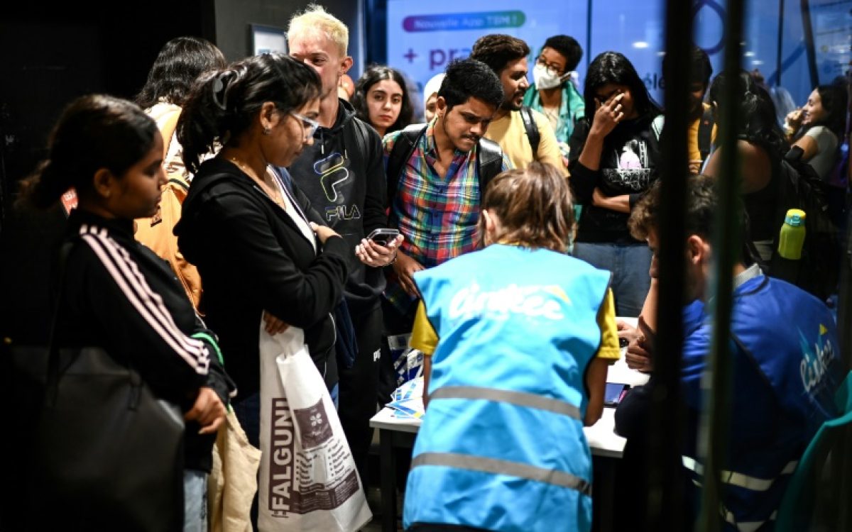 Estudantes inscrevem-se com voluntários antes de uma distribuição de alimentos organizada pela associação Linkee no centro de Bordeaux, sudoeste da França, em 24 de setembro de 2024 - AFP